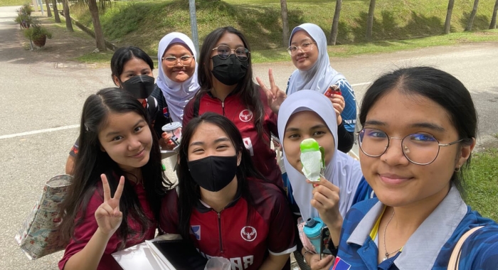 A medium landscape shot of Arianna Saiful posing with a group of friends at Kolej Yayasan Saad, Malacca