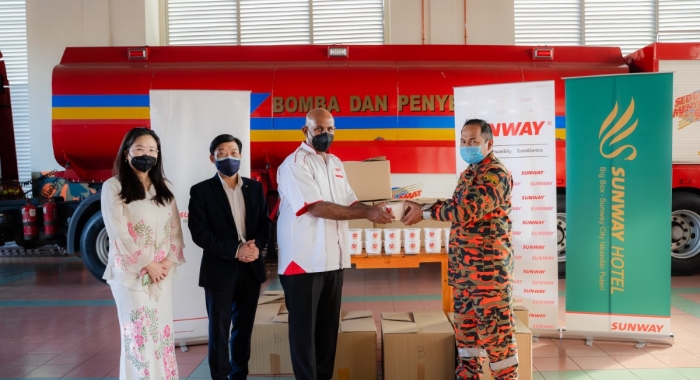 Sunway International Hotels & Resorts senior general manager Kelly Leong and Sunway City Iskandar Puteri CEO Gerard Soosay distributing bubur lambuk to firefighters at the Johor headquarters.
