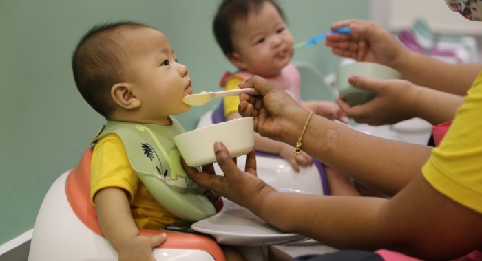 A loose close up shot of Sunway Little Sunshine nursery caregivers feeding infants attentively