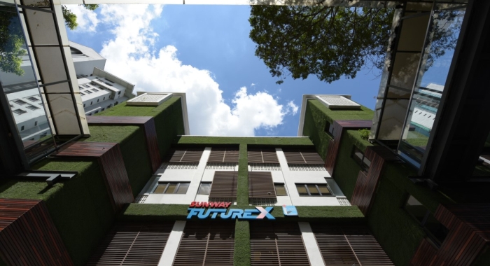 A low-angle landscape shot of Sunway FutureX building façade in Sunway City Kuala Lumpur under clear blue sky