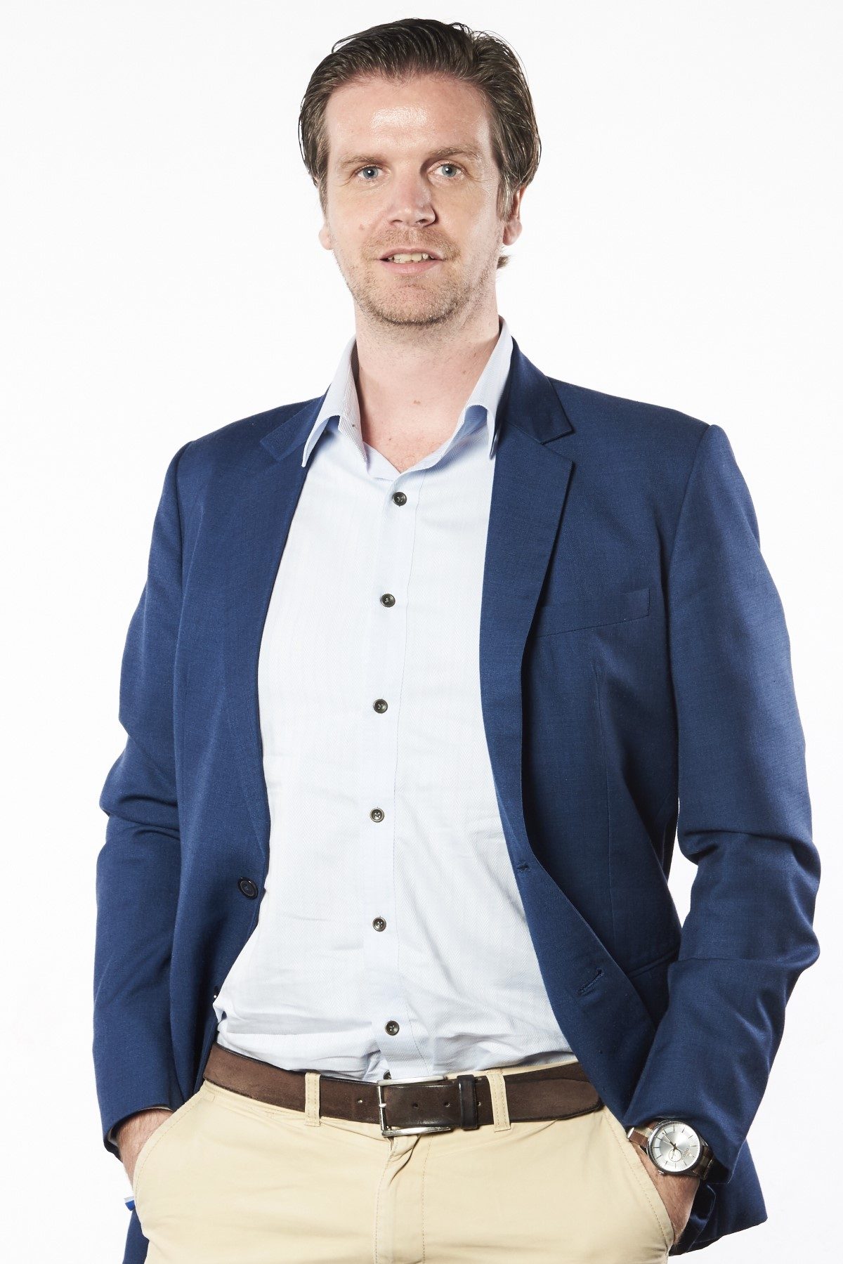 A medium portrait shot of Sunway Group chief innovation officer and director of Sunway iLabs Matt van Leeuwen in a baby blue button up, khaki trousers, brown belt and navy blazer, with both hands tucked neatly in his pockets