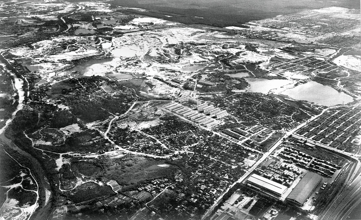 A black and white aerial view of Sunway City Kuala Lumpur in the 1970s, before it has been rehabilitated and currently as a tin-mining wasteland