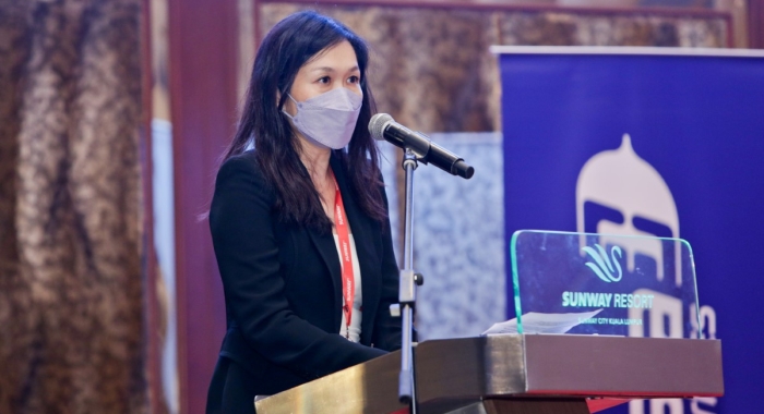 A medium landscape shot of Sunway Group executive director Sarena Cheah giving a speech on-stage behind a Sunway Resort Hotel podium.