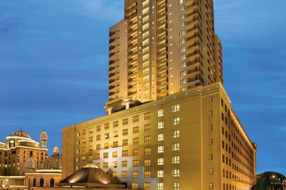 Façade of Suway Pyramid Hotel amid the dusky blue sky, with lights adorning the building.