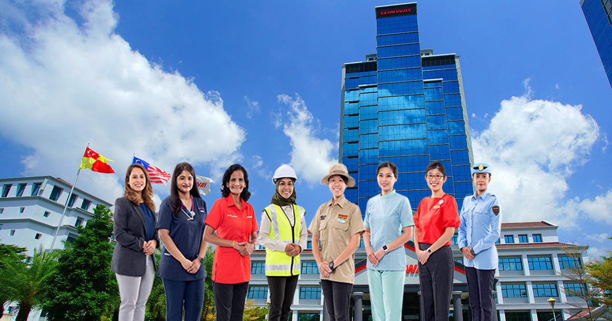 A host of female staff of Sunway lining up in front of Menara Sunway, hued with the blue sky