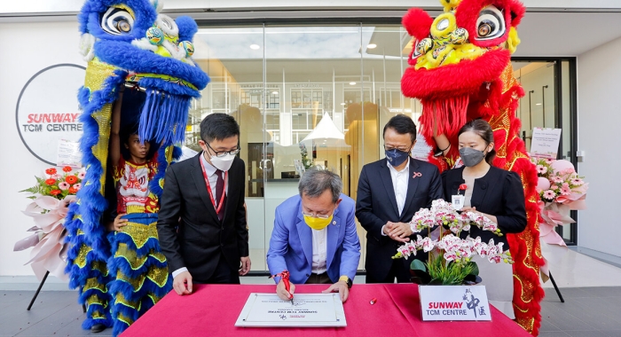 Dr Sim Kui Hian signing a plaque besides Tan Sri Sir Dr. Jeffrey Cheah and others outside of the Sunway Fertility Centre in Kuching, Sarawak.