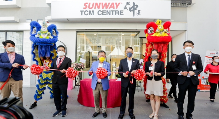A group of people participating in an opening ceremony at Sunway TCM Centre Kuching. Dr. Sim Kui Hian the Deputy Premier and Minister for Public Health, Housing and Local Government of Sarawak and Tan Sri Sir Dr. Jeffrey Cheah and other individuals in formal attire, all wearing face masks.