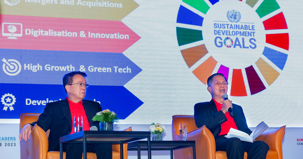Mid shot of Sunway Group founder and chairman Tan Sri Sir Dr. Jeffrey Cheah and Sunway Group president Tan Sri Dato' Chew Chee Kin speaking at the Sunway Leaders Conference 2023, with the UN-SDGs in the background
