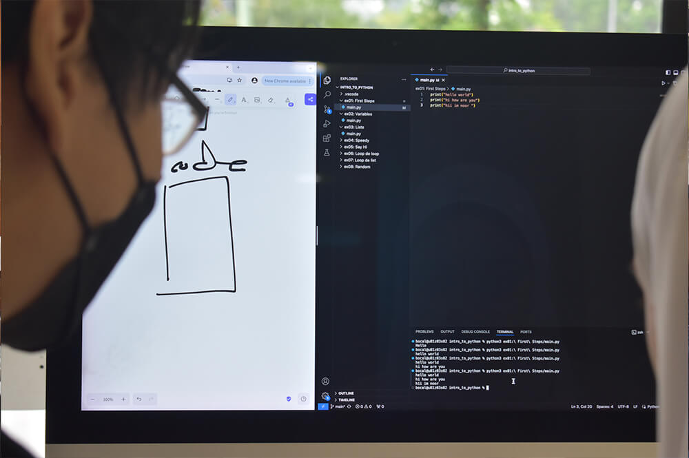 A close-up shot of two students doing Python game design at 42KL