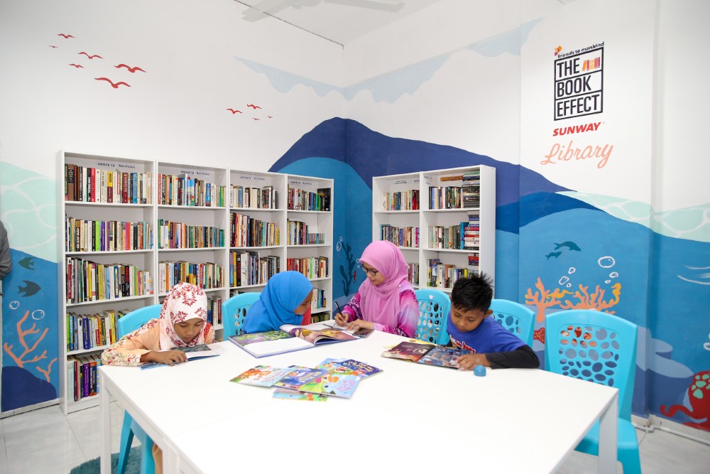 A medium shot of children at the Book Effect Sunway Library at Desa Mentari, with four children reading books