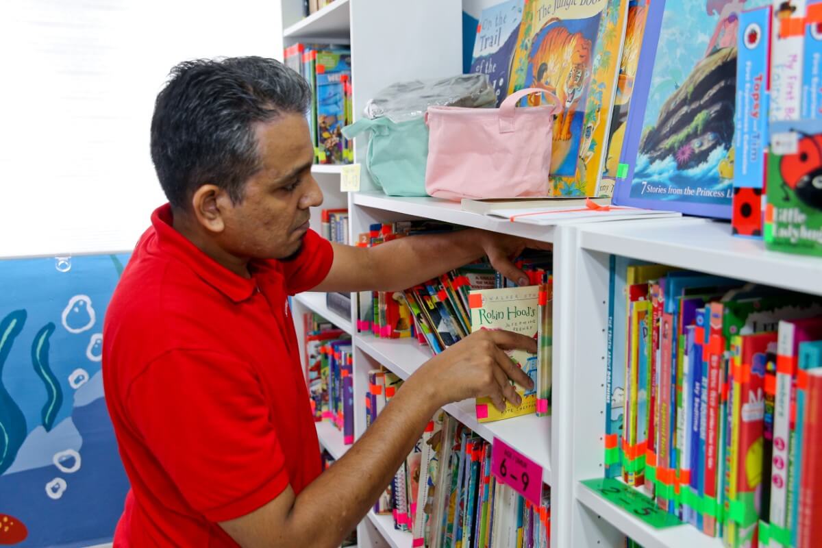 A male Sunway volunteer is arranging books at the Sunway READ library
