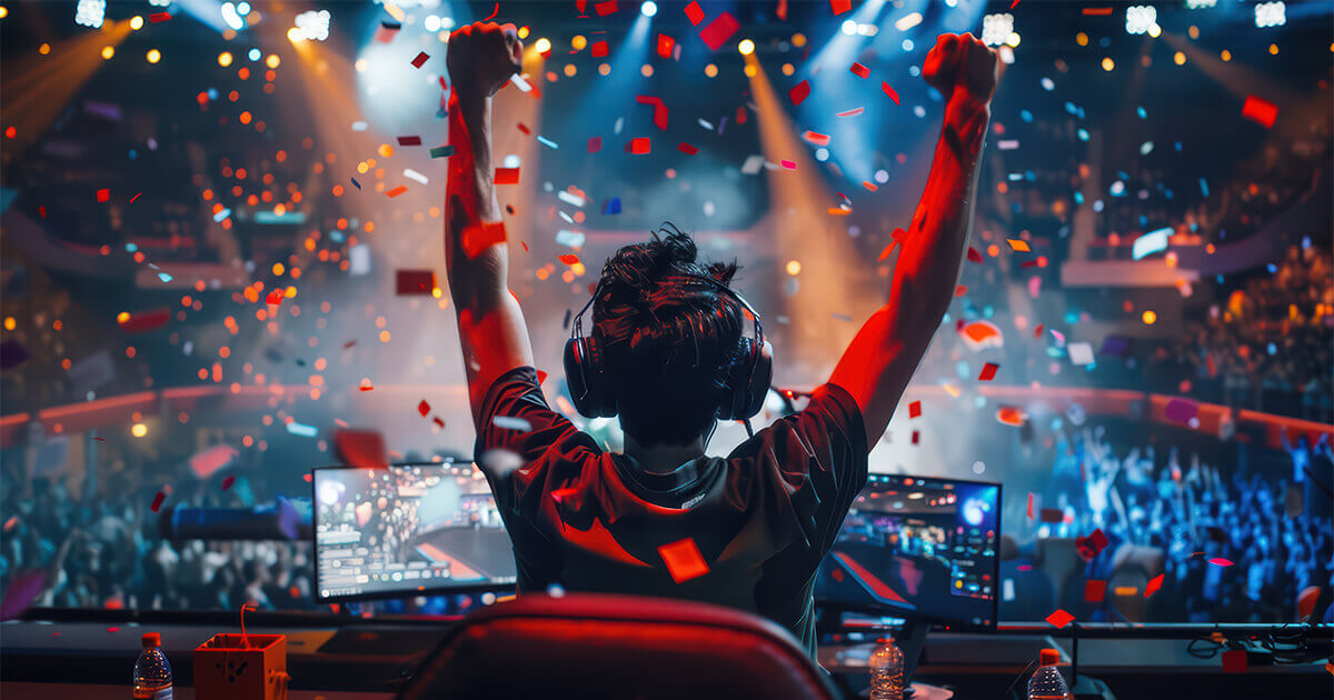 Silhouette of an esports player raising their arms in celebration during a competition