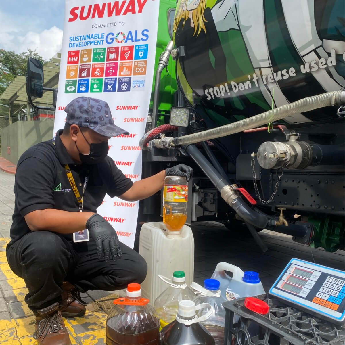 A portrait of a staff from FatHopes Energy dispensing donated used cooking oil into his tanker truck for proper storage before being transformed into biofuels.