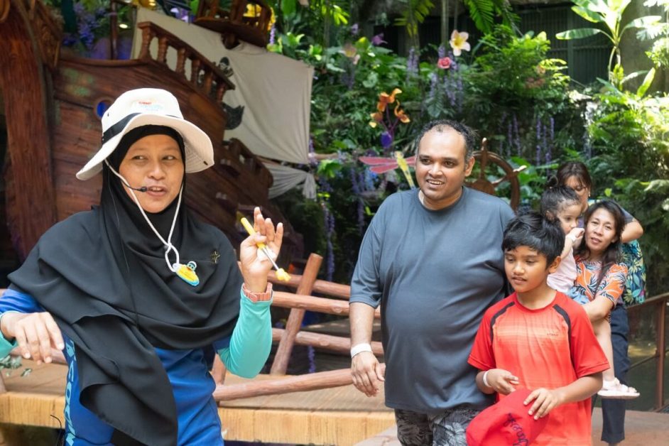 A Sunway Senior Park Ambassador (SPA) is explaining the attractions at the theme park to the guests.
