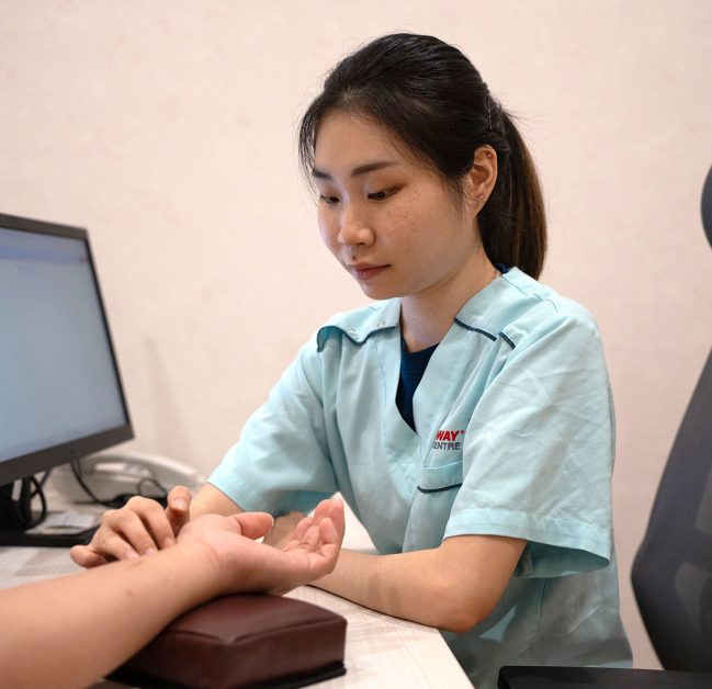 Ms.Tan Suk Meng checking the pulse of her patient